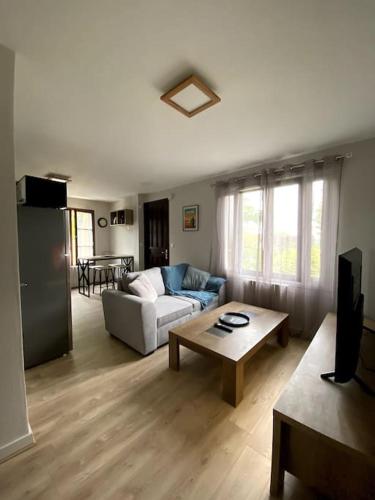 un salon avec un canapé et une table dans l'établissement Appartement 2-4 personnes - Triel Sur Seine, à Triel-sur-Seine