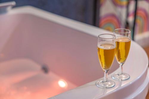 two glasses of beer sitting on a bath tub at Design et Pop avec balnéo in Lyon