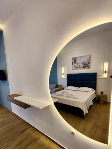 a bedroom with a bed and a large round mirror at Sunrise Apart-Hotel in Ulcinj