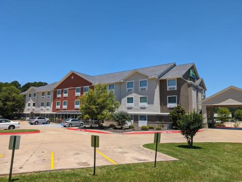 a row of apartment buildings in a parking lot at Holiday Inn Express & Suites - El Dorado by IHG in El Dorado