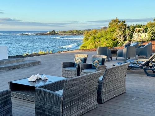 a patio with wicker chairs and tables and the ocean at Ocean View Pico in Madalena