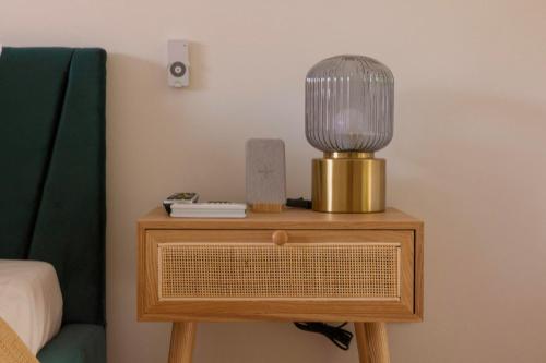 a lamp on a table next to a bed at Nyárfás Panoráma Vendégház in Dunavarsány