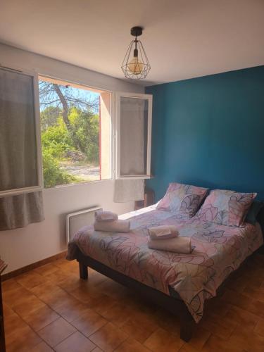 ランブクにあるMaison T4, campagne Provençale calme, tout confortの青い壁と窓のあるベッドのある寝室