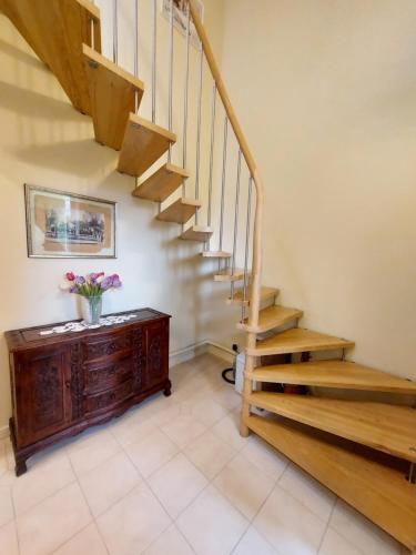 a staircase in a home with a vase of flowers on a cabinet at Trakai Castle View Villa55 in Trakai