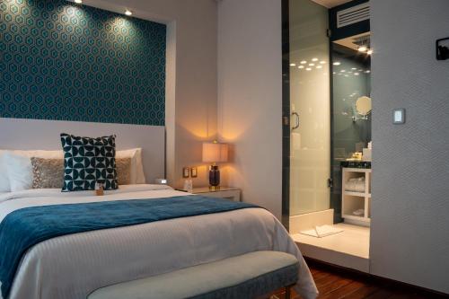 a bedroom with a bed with a blue accent wall at 1850 Hotel Boutique in Guanajuato