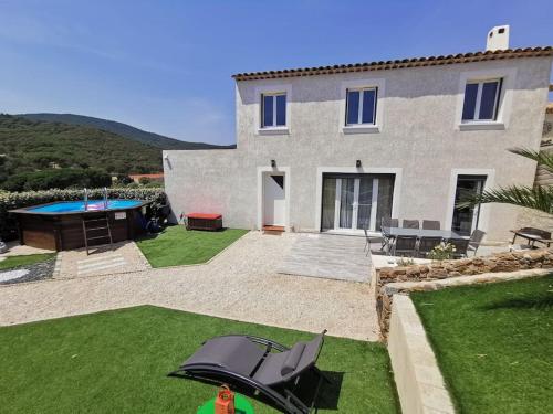 une personne debout devant une maison avec un parapluie dans l'établissement Magnifique maison individuel avec piscine hors-sol, à Sainte-Maxime