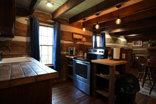 a kitchen with wooden walls and a stove top oven at Extended Stays by Lee House Inn in Maysville