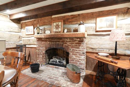 a living room with a brick fireplace with a table at Extended Stays by Lee House Inn in Maysville