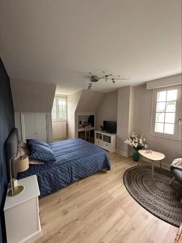 a bedroom with a blue bed and a rug at Les Tulipes in Antrain