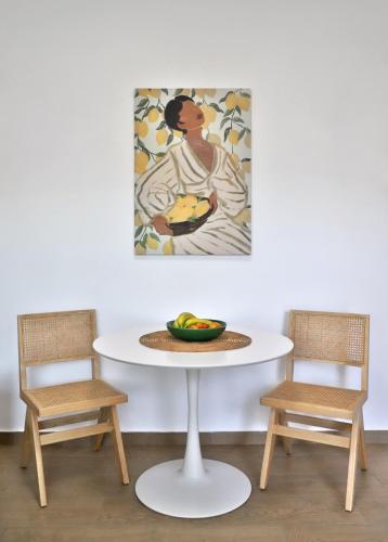 a table with two chairs and a bowl of fruit on it at Lemoni House in Petras, Sitia, by Comfortbnb in Sitia