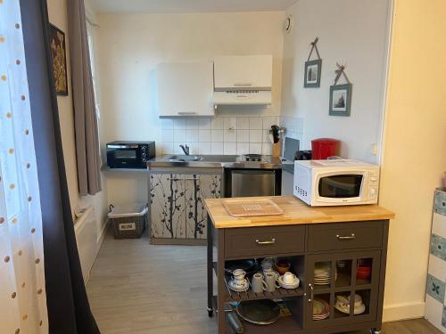 une petite cuisine avec un four micro-ondes sur une table dans l'établissement Claids coutainville, à Agon-Coutainville