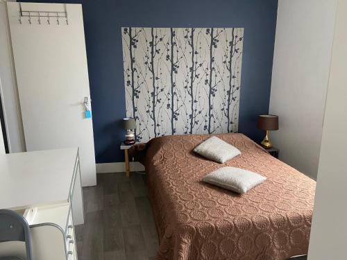 une chambre avec un lit avec deux oreillers dessus dans l'établissement Claids coutainville, à Agon-Coutainville