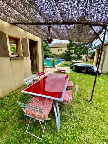 - une table et des chaises sous un parasol dans la cour dans l'établissement Maison 6p, 3ch, piscine, jacuzzi, cuisine d'été, jardin clos, à Alba La Romaine
