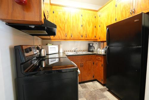 a kitchen with a black refrigerator and wooden cabinets at Extended Stays by Lee House Inn in Maysville