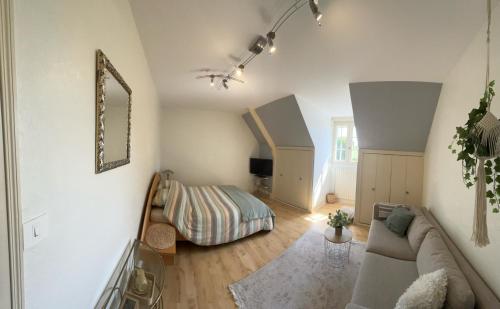a living room with a couch and a bed at les Tulipes in Antrain