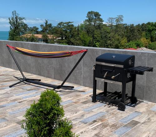 a grill and a hammock on a patio at Penthouse Sea Breeze in K'obulet'i