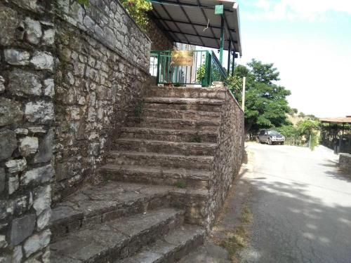 a stone wall with stairs next to a building at Kallistws House in Zigovístion