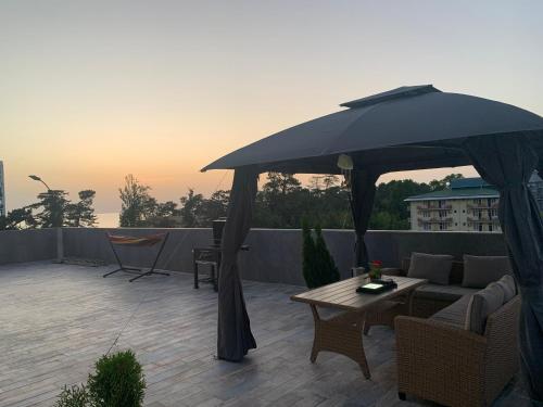 a large black umbrella sitting on top of a patio at Penthouse Sea Breeze in K'obulet'i