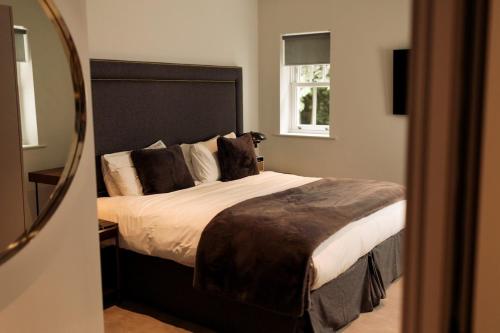 a bedroom with a large bed and a mirror at Milsoms Kesgrave Hall in Ipswich