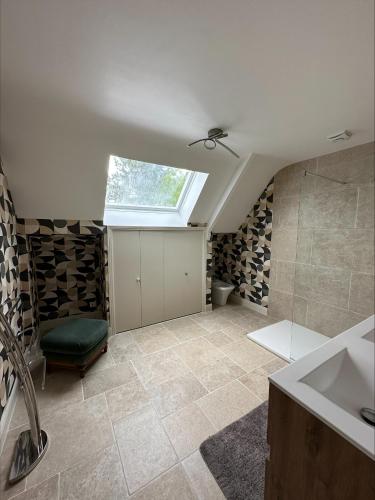 La salle de bains est pourvue d'un lavabo et d'une lucarne. dans l'établissement les Tulipes, à Antrain