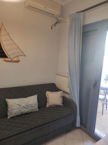 a black couch in a room with a window at Dimitris Guesthouse in Kapótidhes