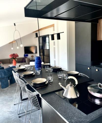 une cuisine avec un comptoir noir avec des chaises et des tables dans l'établissement Appartement moderne dominant la ville, à Pontarlier
