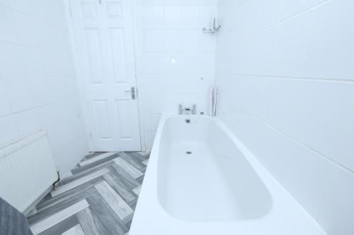 a white bathroom with a shower and a toilet at BEAUTIFUL 4 BED HOUSE IN Cul-De-Sac in Erith