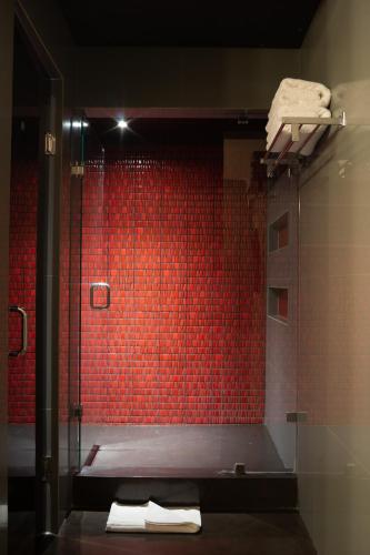 a bathroom with a red tiled shower with towels at 1850 Hotel Boutique in Guanajuato