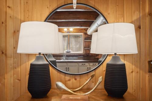 two lamps sitting on a table in front of a mirror at Apres Chalet in Columbia Falls