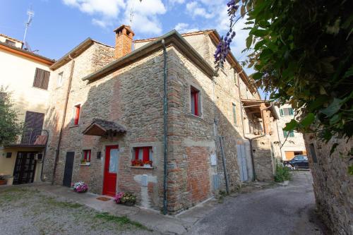 a brick building with a red door on a street at Il Gatto e la Luna in Arezzo