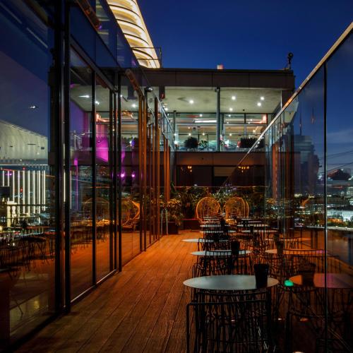 a balcony with tables and chairs on a building at Sea Containers London in London