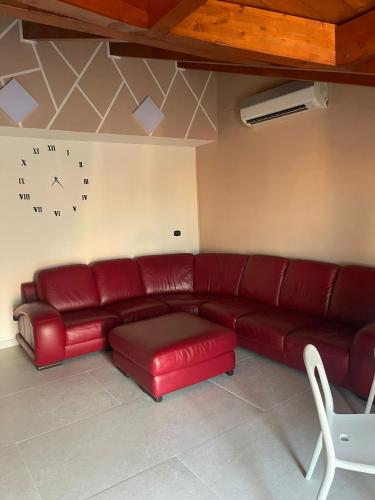 a red couch in a living room with a clock on the wall at Vesux Apartments in Naples