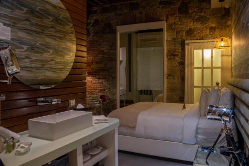 a bedroom with a bed and a sink and a mirror at 1850 Hotel Boutique in Guanajuato