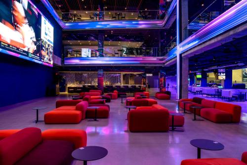 a lobby with red chairs and a bar at The STRAT Hotel, Casino & Tower in Las Vegas