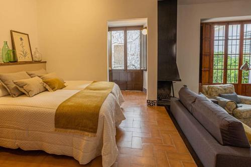 1 dormitorio con cama, sofá y chimenea en Apartamento Alvear, en Montilla