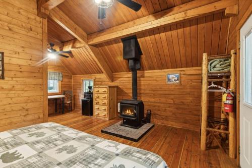 a bedroom with a fireplace in a log cabin at Lost Horse Lodge King Cabin 18 in Darby