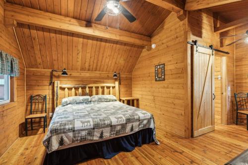 a bedroom with a bed in a room with wooden walls at Lost Horse Lodge King Cabin 18 in Darby