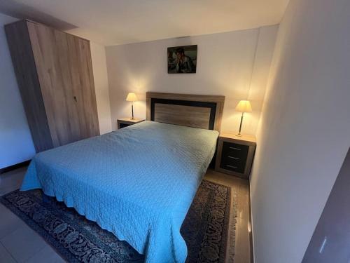 une chambre avec un lit avec un couvre-lit bleu dans l'établissement Magnifique appt T2 avec Piscine, à Saint-Cyr-sur-Mer