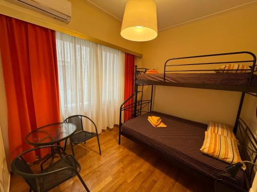 a bedroom with two bunk beds and a table and chairs at Petaluda House 5 in Athens