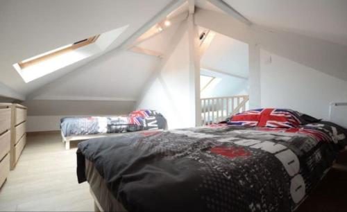 - une chambre mansardée avec un lit et un canapé dans l'établissement Gite Des Ameraudes, à Macey