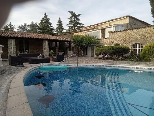une piscine devant une maison dans l'établissement Mas de la berlusiere, à Saint-André-de-Cruzières