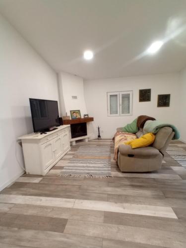 a living room with a couch and a tv at O Mundo da Lua in Azeitao