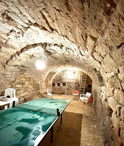 Cette chambre est dotée d'une table et d'un mur en pierre. dans l'établissement Mas Chantequinson, à Les Assions