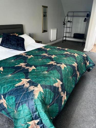 a bedroom with a bed with a green comforter at The Townhouse in Gainsborough