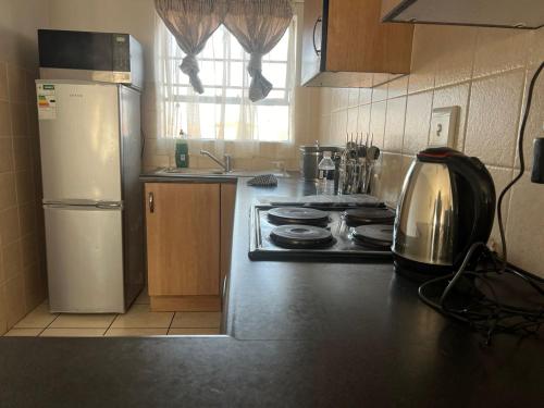 a kitchen with a stove and a refrigerator at Nicole Guest Apartments in Germiston