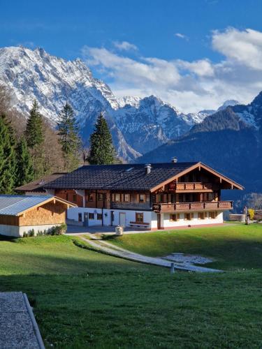 a large building with mountains in the background at Ferienwohnung Datzmannlehen mit traumhaften Bergblick und Sauna in Ramsau
