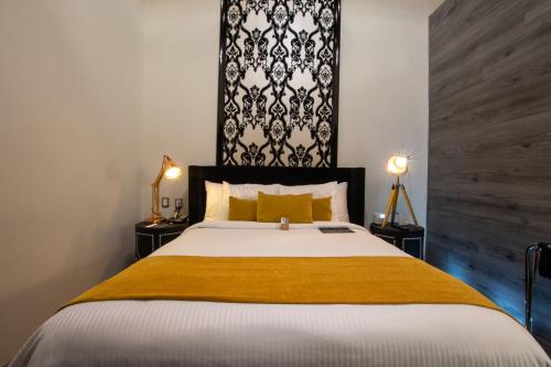 a bedroom with a large bed and two lamps at 1850 Hotel Boutique in Guanajuato