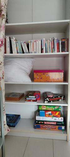 a book shelf filled with books next to a bed at Maison d'Hestia, charme, piscine, proche du bord de mer et de Royan in Arces-sur-Gironde