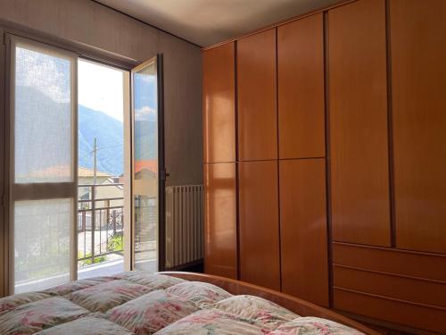 a bedroom with a bed and a large window at Cà Maria Maurela in Ossuccio