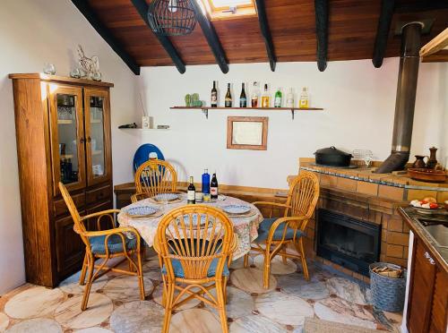 a dining room with a table and chairs and a fireplace at Finca mit Meerblick und Jacuzzi in Las Cruces